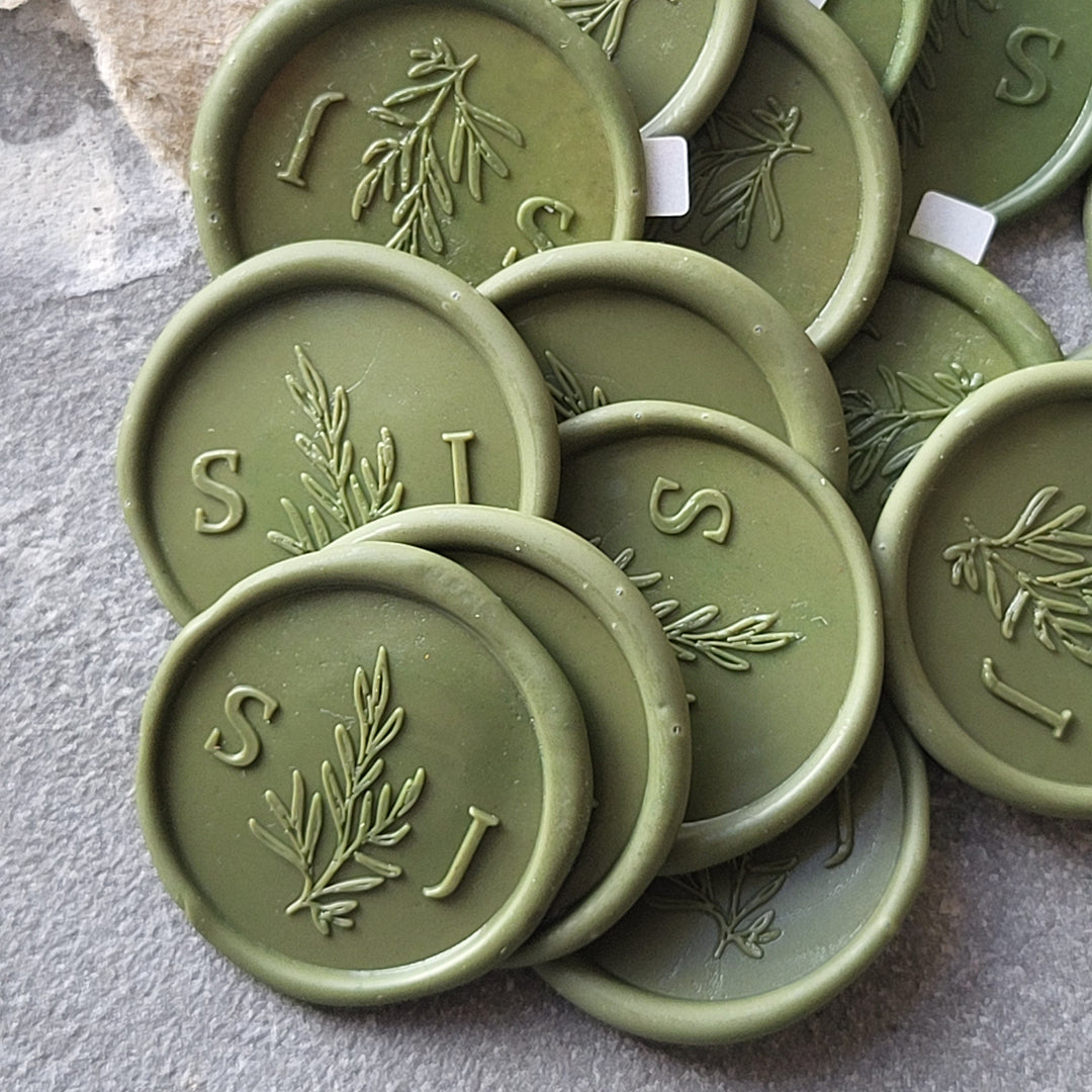 Handmade green 'Willow' monogram wax seals with initials 'S' and 'J,' showcasing intricate botanical detailing and adhesive backing.