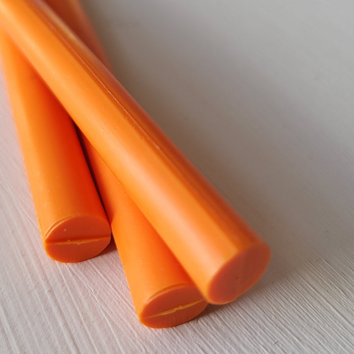 Close-up of 7mm tangerine sealing wax sticks, glue gun compatible, ideal for crafting wax seals. Made in the UK.