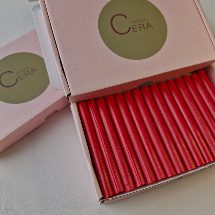 Close-up of a box containing 30 handmade raspberry red 11mm wax sealing sticks, ideal for sealing tasks, with Atelier Cera branding.