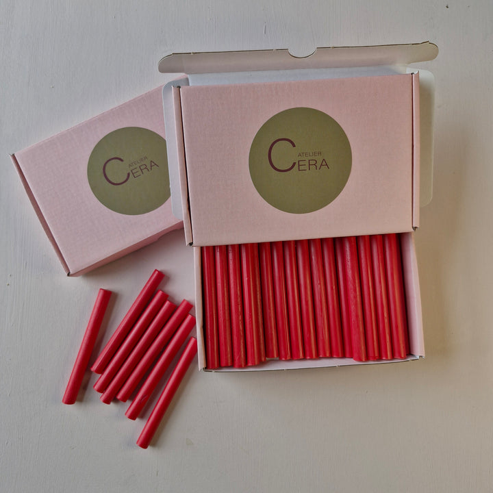 Open box of 30 raspberry red 11mm wax sealing sticks with additional sticks arranged beside it, featuring Atelier Cera branding.