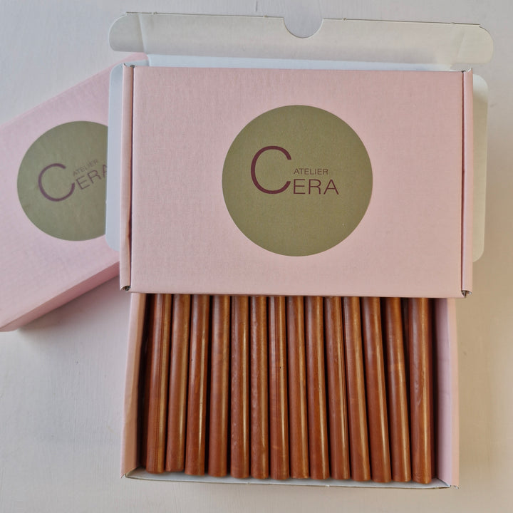 Close-up of a pink box with 30 copper wax sticks, featuring Atelier Cera branding. Designed for sealing and crafting purposes.