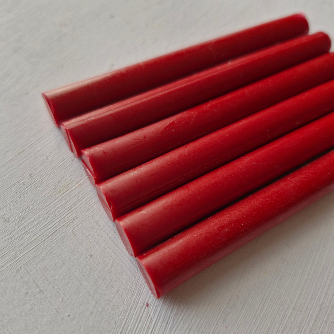 Close-up of raspberry red 11mm sealing wax sticks from a box of 50, ideal for crafts, seals, and creative projects.