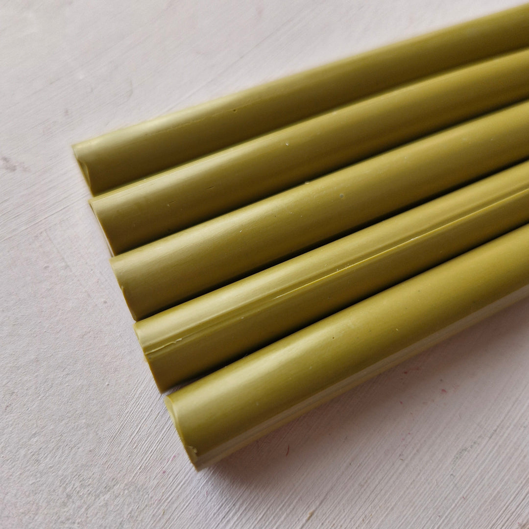 Close-up of 11mm Dijon-colored office glue sticks from a box of 50, ideal for crafting and office use.