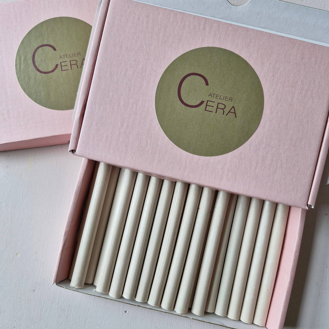 Open pink box labeled 'Atelier Cera' displaying 30 neatly arranged 11mm champagne pearl sealing wax sticks. Ideal for sealing rituals.