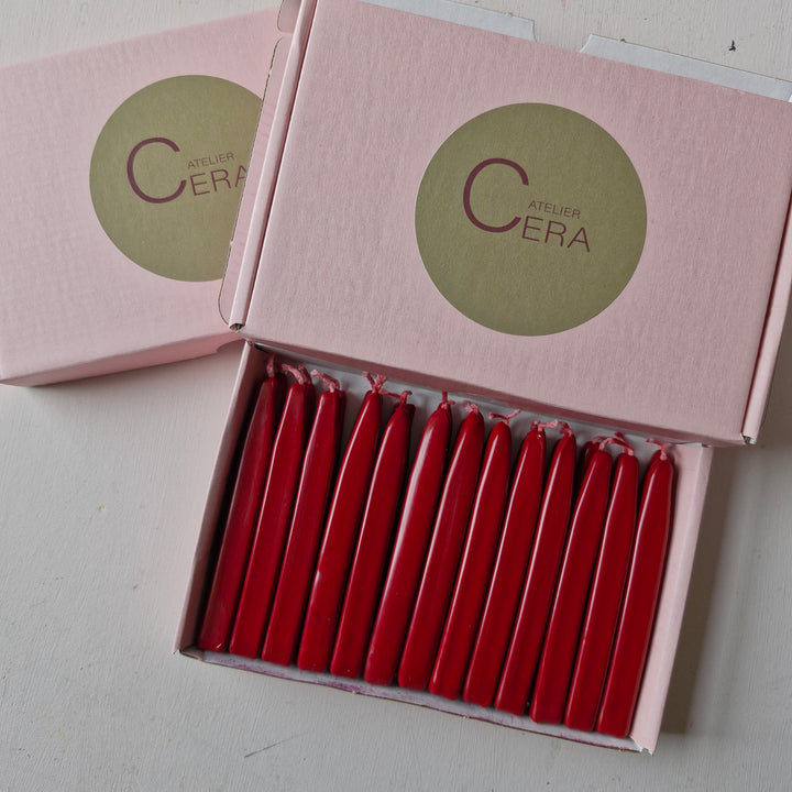 Two pink Atelier Cera boxes with one open, displaying 26 red sealing wick wax sticks neatly arranged.