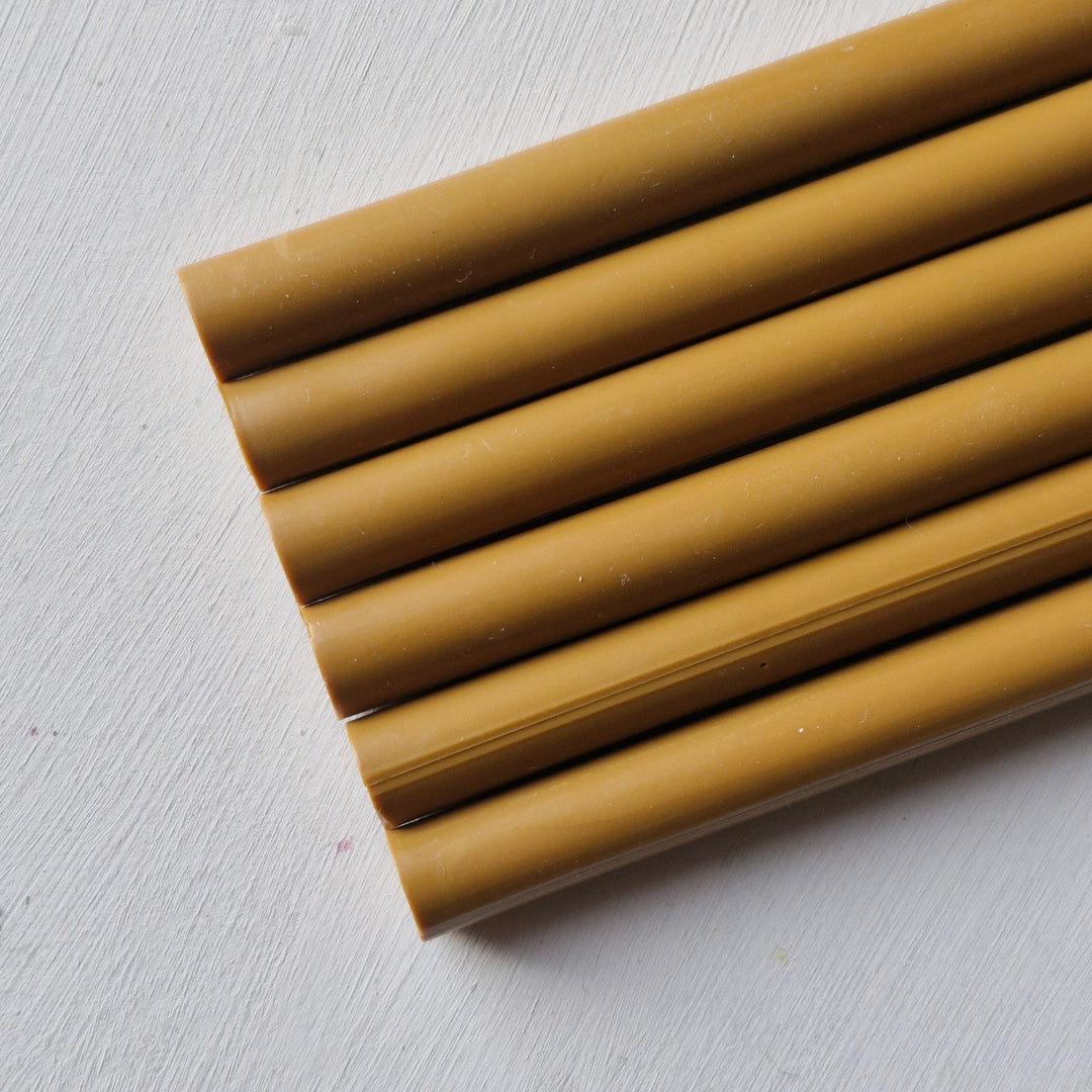 Set of 11mm toffee sealing wax sticks displayed on a white background, showcasing their smooth finish and crafting versatility.