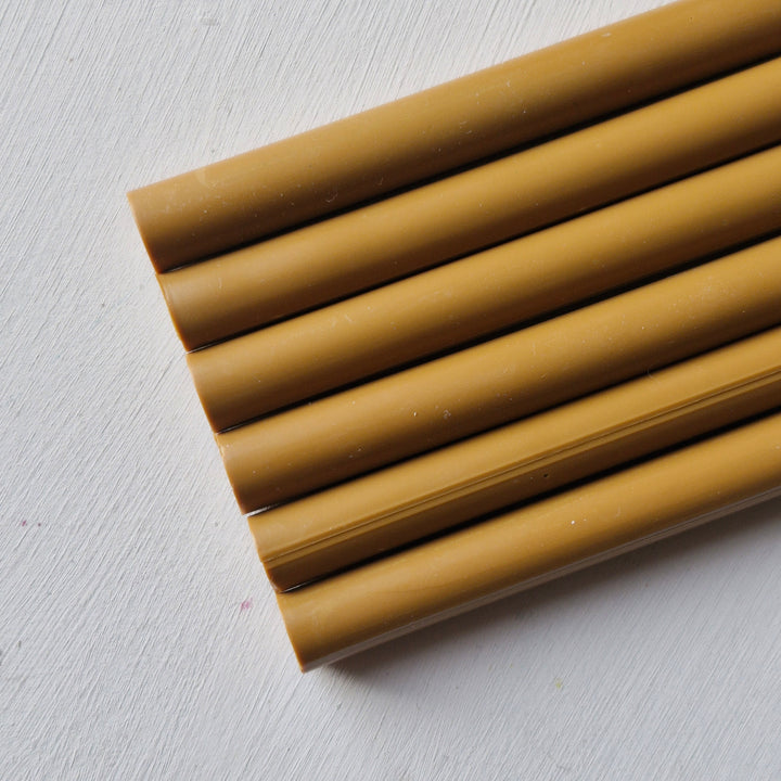 Set of 11mm toffee sealing wax sticks displayed on a white background, showcasing their smooth finish and crafting versatility.