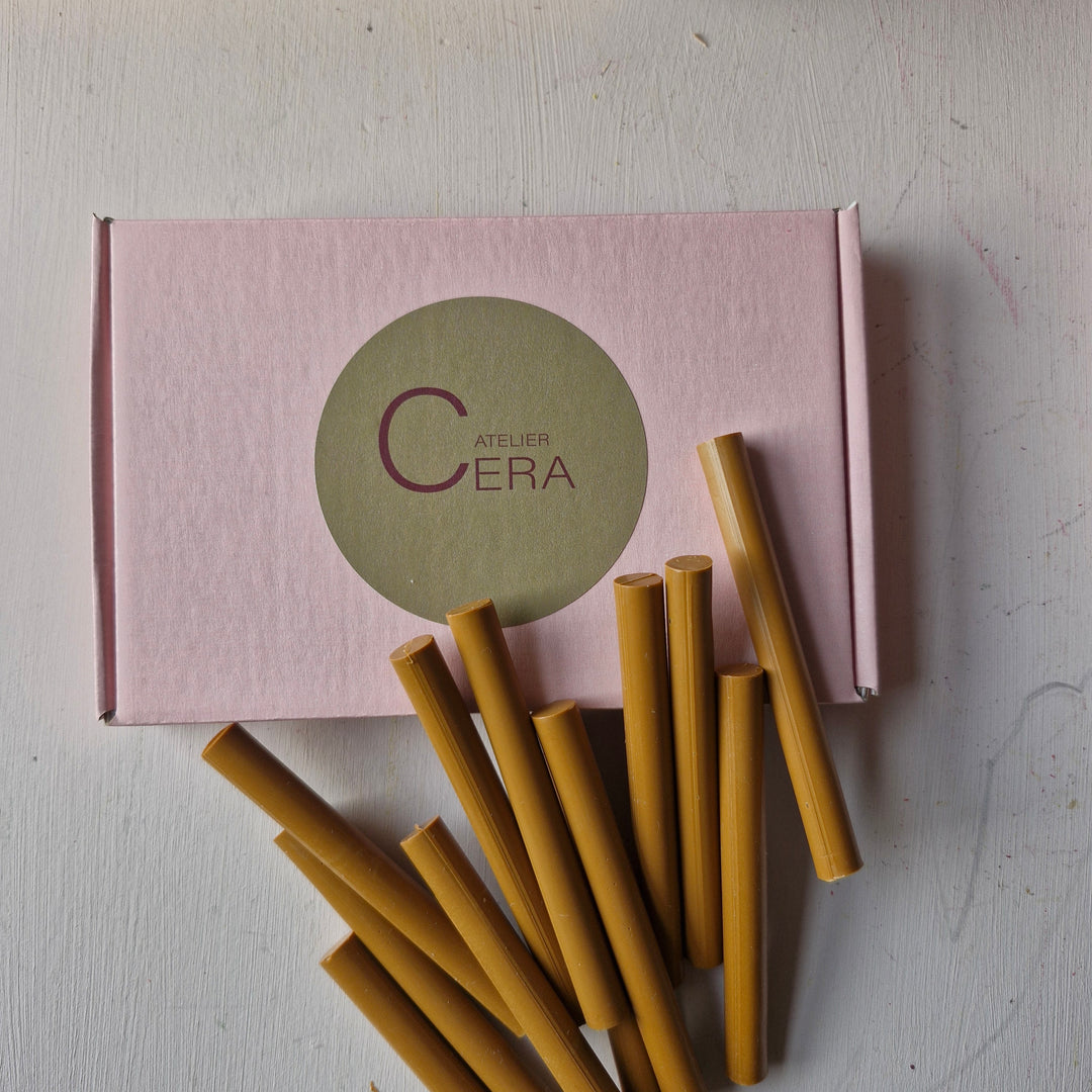 Box of 250 toffee-colored 11mm sealing wax sticks with a pink Atelier Cera branded box in the background.