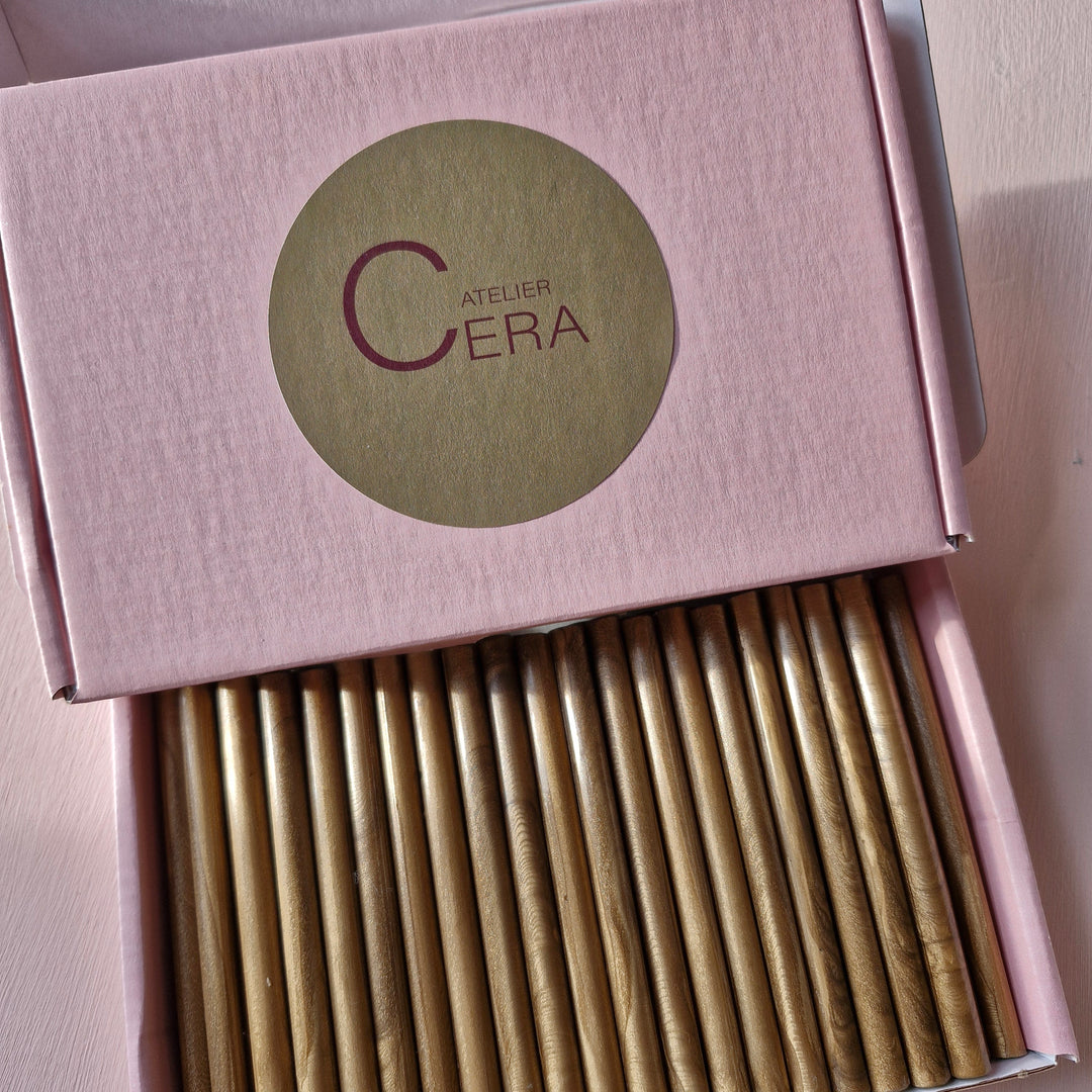 Box of gold 7mm sealing wax sticks with handmade quality, displayed in a pink box labeled 'Atelier Cera.'