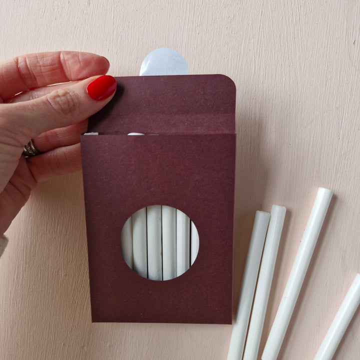 Pack of 10 Chelsea White 7mm sealing wax sticks in a burgundy box with a circular window. Ideal for wax seals on envelopes and invitations.