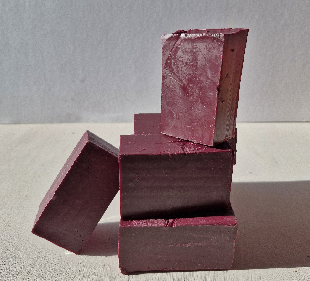 Burgundy bottle sealing wax blocks stacked and arranged on a white surface, ideal for crafting and sealing projects.