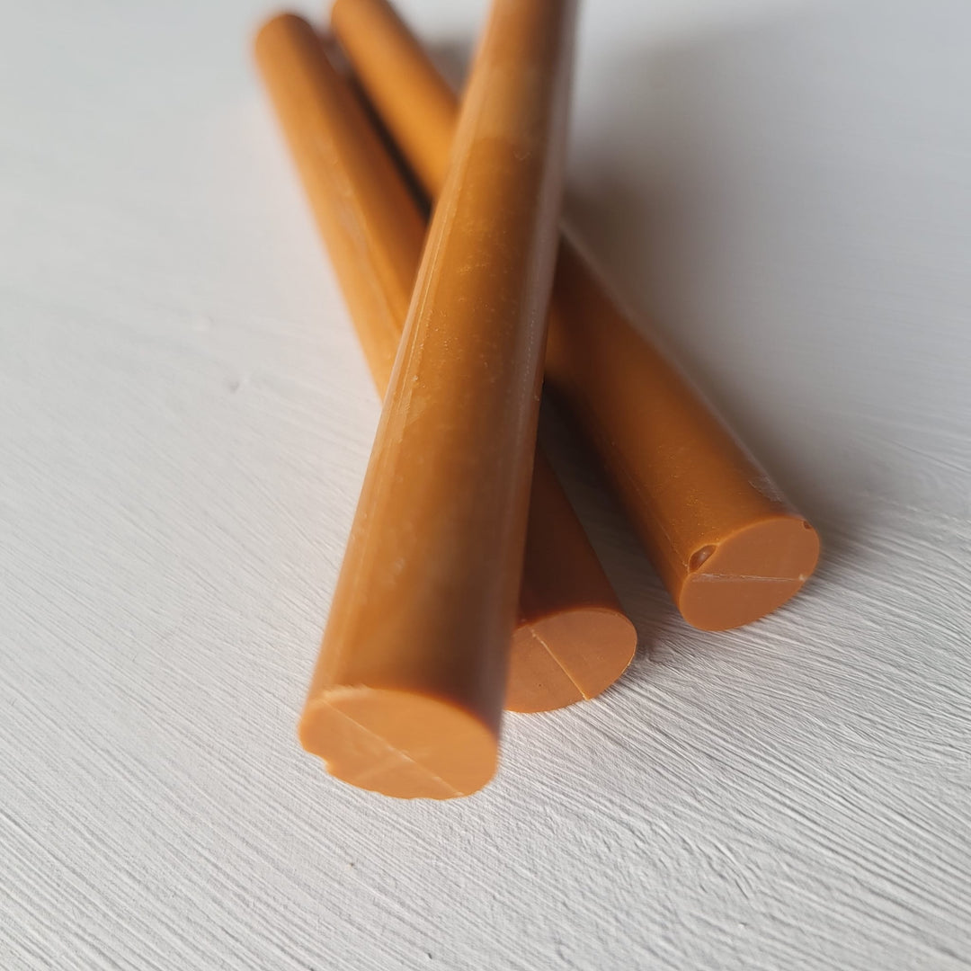 Angled view of three sienna 11mm sealing wax sticks arranged on a white surface, ideal for crafting and sealing projects.