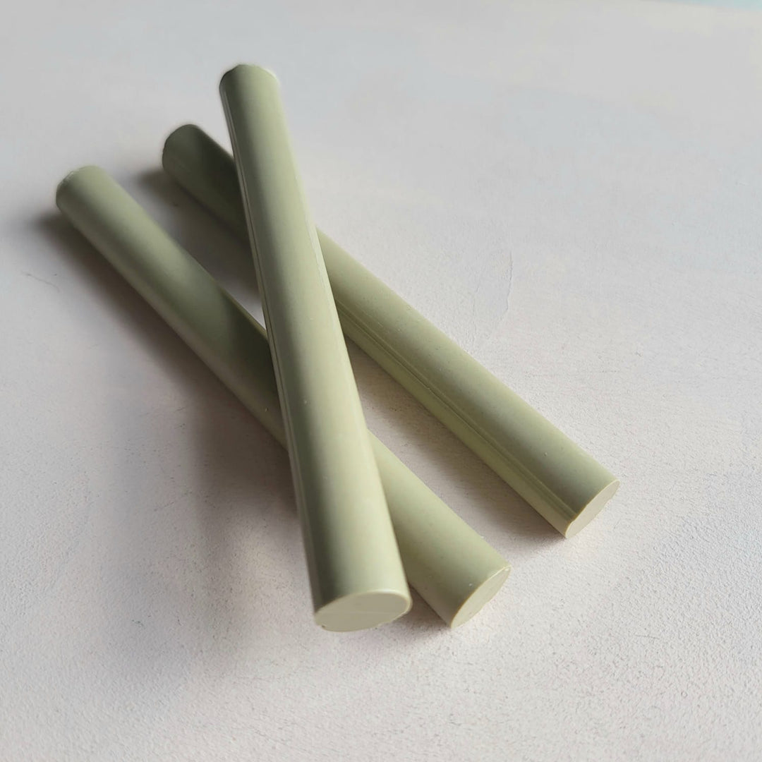 Three pistachio-colored 11mm sealing wax sticks from a pack of 10, ideal for arts and crafts projects like envelope sealing.