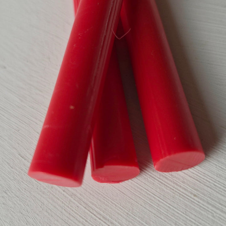 Close-up of raspberry red 11mm sealing wax sticks from a 10-pack, ideal for crafting and office use in sealing documents.