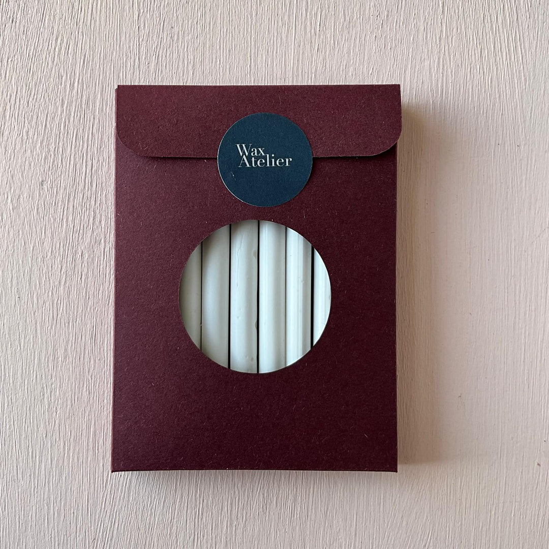 Pack of 10 Chelsea White 7mm sealing wax sticks in a burgundy envelope with a circular window. Ideal for wax seals on envelopes and invitations.