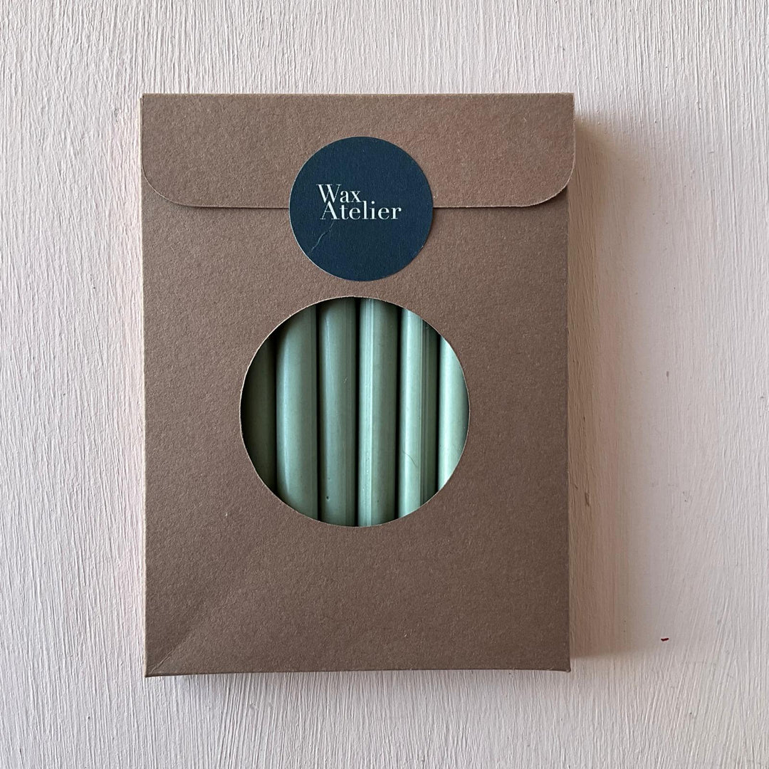 Pack of 10 sage green sealing wax sticks in eco-friendly brown packaging with a circular window. Handmade 7mm wax sticks for crafting and sealing.