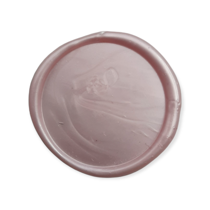 Blush pink wax seal showcasing a smooth finish, perfect for elegant stationery and decorative purposes.