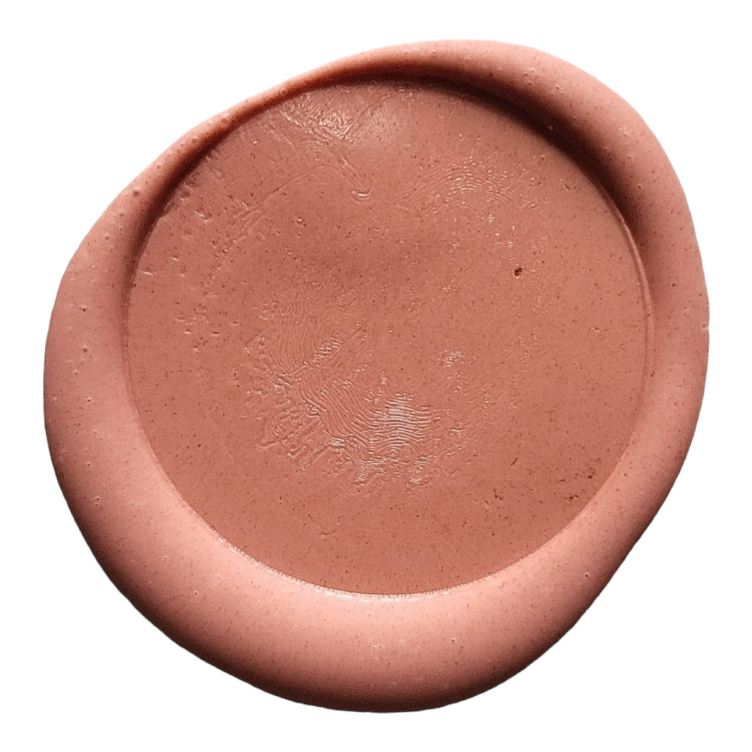 Close-up of a terracotta wax seal showcasing its smooth texture and circular design, perfect for sealing envelopes or crafts.