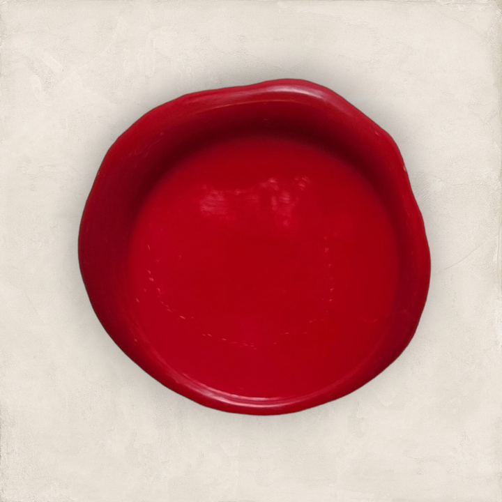 Melted red sealing wax in a circular shape on a light background. Ideal for creating seals on envelopes or documents.