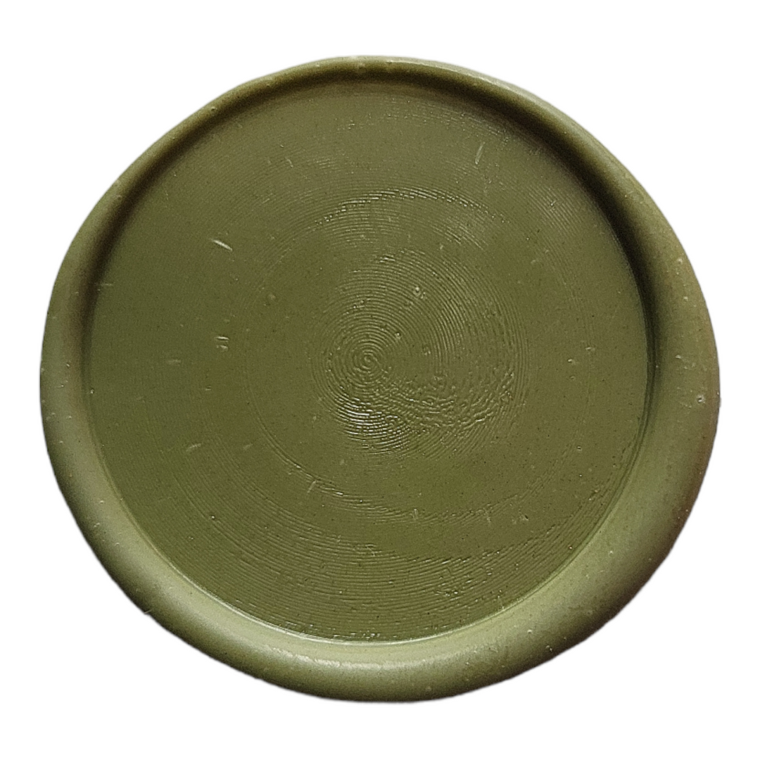 Close-up of an olive green wax seal with a smooth, circular finish. Perfect for decorative and functional sealing applications.