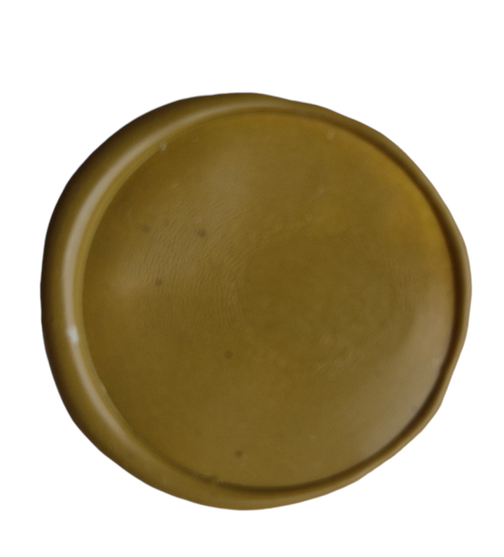 Close-up of a melted Dijon sealing wax impression in olive green, showcasing its smooth texture and finish.