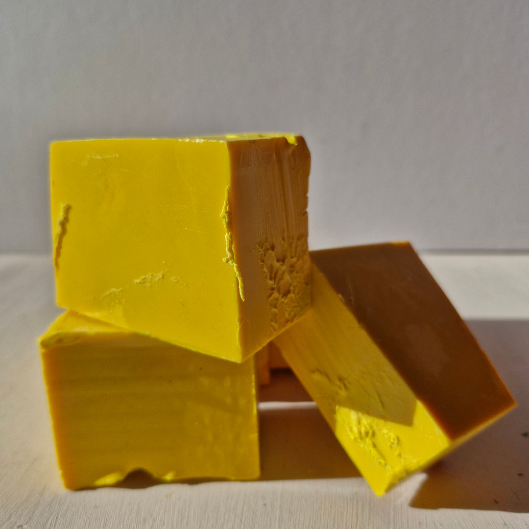 Bright yellow bottle sealing wax blocks stacked on a white surface, ideal for arts and crafts projects.