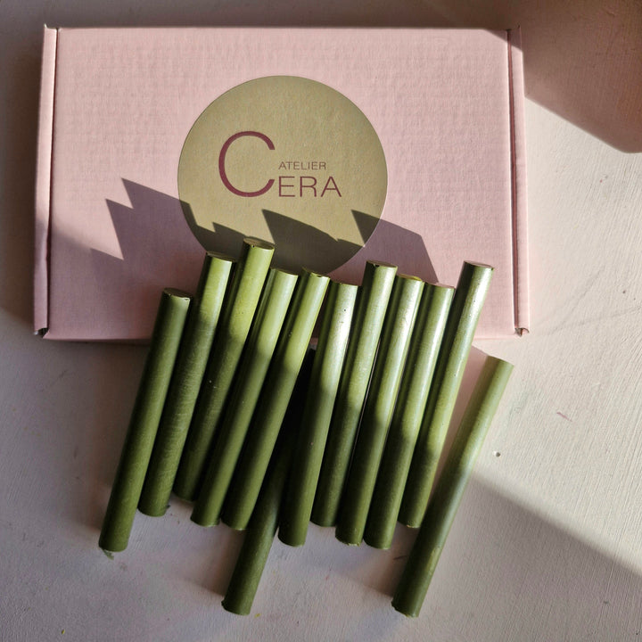 Box of 250 olive green 11mm sealing wax sticks displayed with several sticks arranged in front. Ideal for crafts and handmade sealing projects.