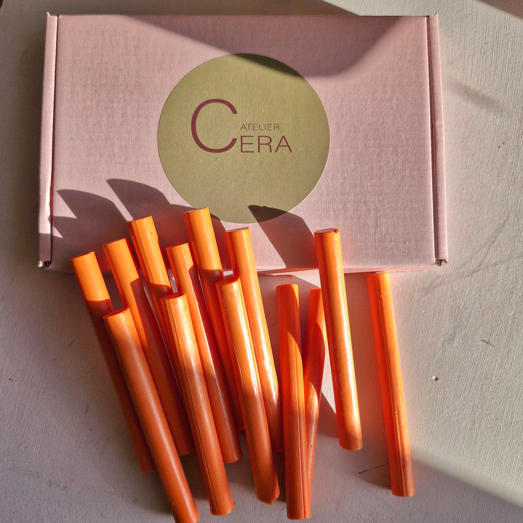 Box of 250 tangerine-colored 11mm sealing wax sticks displayed with several sticks placed outside the box. Ideal for office and crafting use.