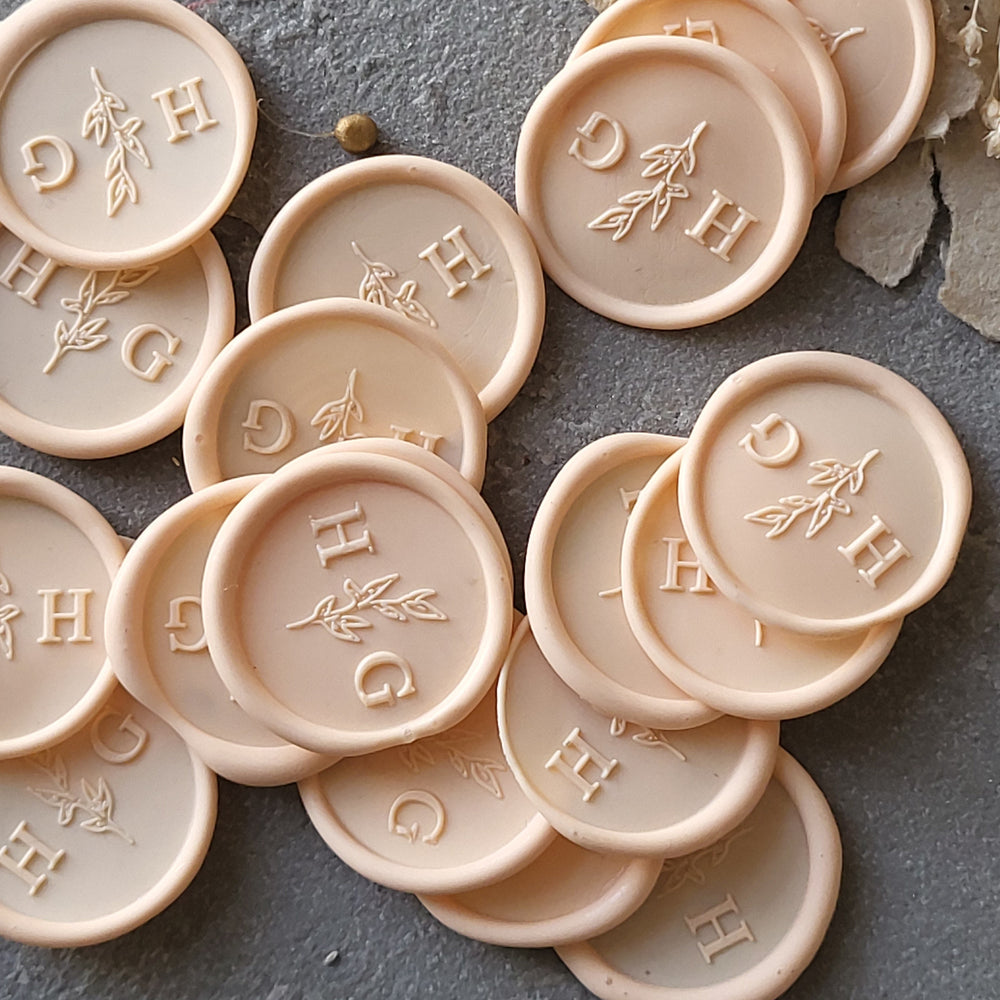 Handmade 'Meadow' monogram wax seals featuring initials and a botanical motif, perfect for personalized gifts.