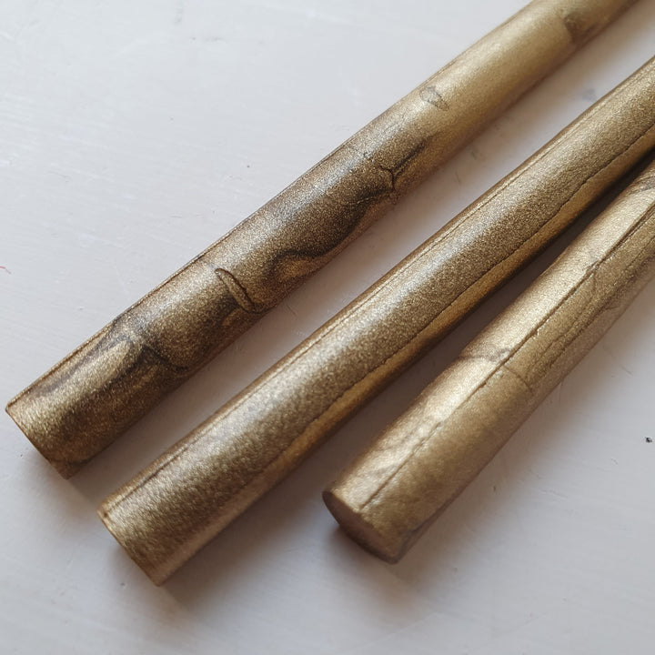 Close-up of 7mm gold wax sealing sticks for glue gun use, showcasing a metallic finish. Ideal for creating 4-5 seals per stick.