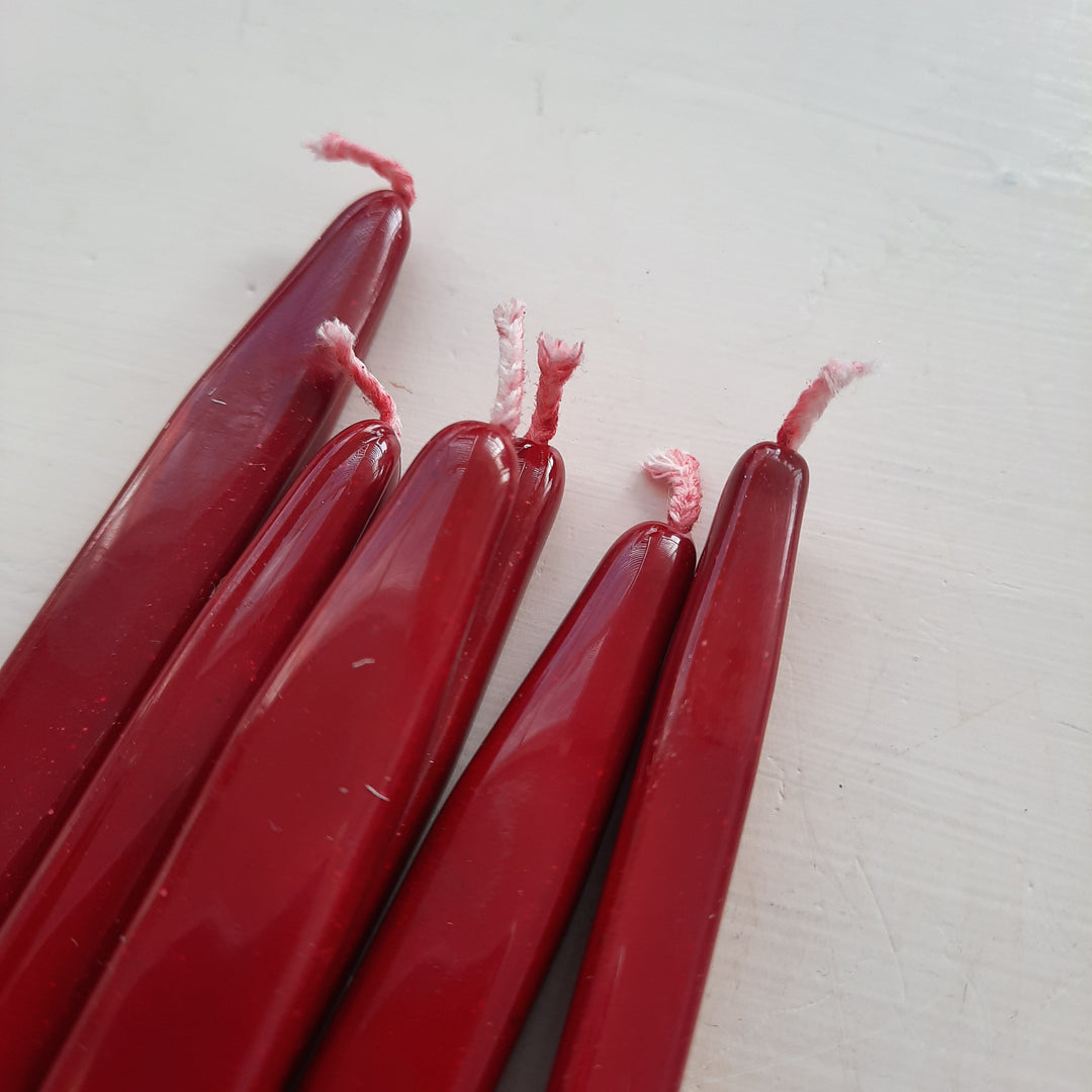 Close-up of red sealing wick wax sticks with pink wicks, showcasing smooth finish and traditional design. Perfect for seal-making.